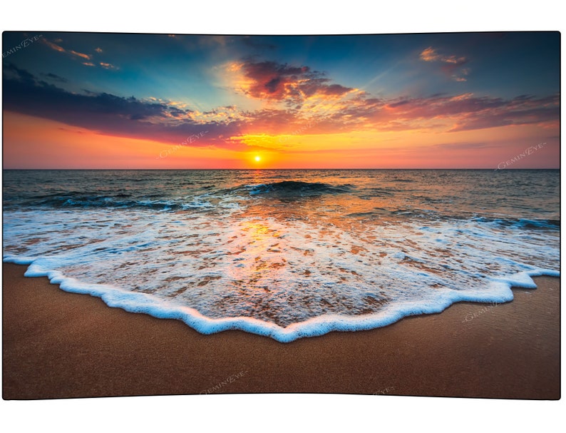 May include: A scenic sunset over the ocean with a sandy beach and foamy waves crashing on the shore.