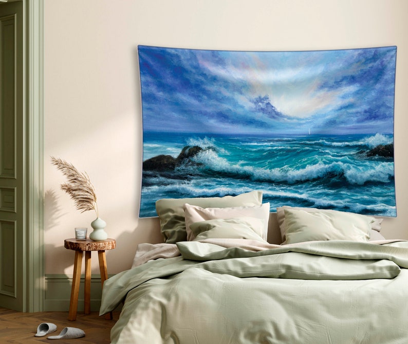 May include: A tapestry featuring a painting of a stormy sea with large waves crashing against rocky shores. The sky is a mix of blue and gray with a hint of pink in the clouds.