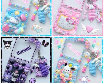 Pode incluir: Quatro capas de telefone decoradas com temas diferentes. A capa do canto superior esquerdo é azul e branca com um personagem Sanrio, a capa do canto superior direito é rosa e branca com um personagem Sanrio, a capa do canto inferior esquerdo é preta e roxa com um personagem Kuromi, e a capa do canto inferior direito é azul e branca com um personagem Sanrio.