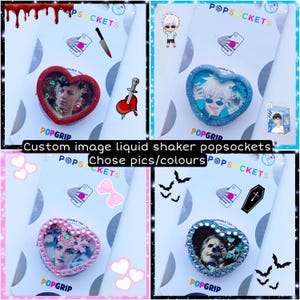 Op de afbeelding: Vier hartvormige telefoonbeugels met aangepaste afbeeldingen en glitter erin. De beugels zijn in rood, blauw, roze en lichtblauw. De afbeeldingen zijn van een persoon met een mes, een persoon met een zwaard, een persoon met een bloem en een persoon met een kruis. De tekst "Custom image liquid shaker popsockets" staat op de afbeelding.