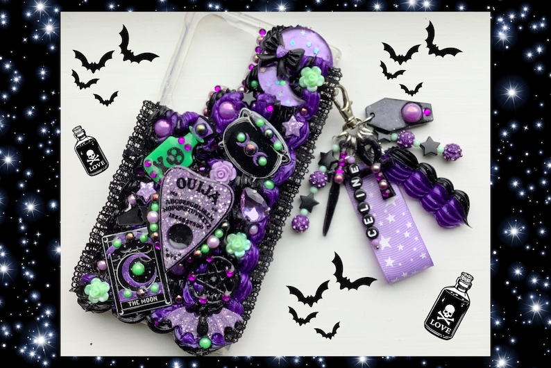 Peut inclure: Une coque de t&eacute;l&eacute;phone violette et noire avec une vari&eacute;t&eacute; de breloques, dont une lune croissante, un chat noir, un planchette de Ouija et une fiole de potion. La coque est d&eacute;cor&eacute;e de paillettes, de strass et d'autres embellissements.