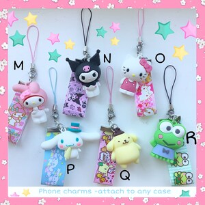 Może przedstawiać: Zestaw 8 charm&oacute;w do telefonu z popularnymi postaciami z kresk&oacute;wek. Charmsy są wykonane z kolorowego plastiku i mają r&oacute;żne wzory, w tym Hello Kitty, My Melody, Keroppi i wiele innych. Charmsy są przymocowane do kolorowych wstążek z nadrukowanymi nazwami postaci. Charmsy są oznaczone literami od M do R.