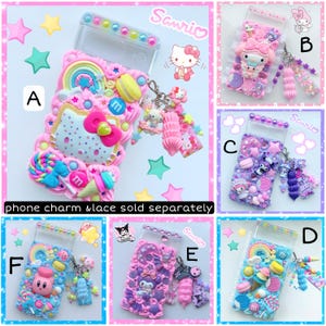 May include: Six different phone cases decorated with colorful 3D embellishments, including candy, stars, and cartoon characters. The cases are all clear and have a Sanrio logo on them. The text "phone charm & lace sold separately" is written below the cases.