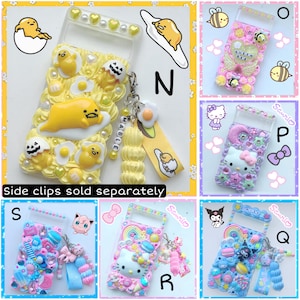 May include: A collection of 10 colorful phone cases decorated with various cartoon characters, including Hello Kitty, Gudetama, and Sanrio characters. Each case features a unique design with 3D embellishments, glitter, and charms. The cases are labeled with letters N, O, P, Q, R, and S.