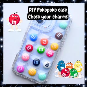 Puede incluir: Funda transparente para teléfono decorada con caramelos M&M's de colores. La funda tiene un patrón de cuadrícula y los caramelos son de varios colores, incluyendo rojo, azul, verde y amarillo. El texto en la imagen dice "DIY Pokopoko case Chose your charms."