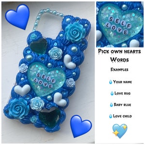 May include: A blue phone case decorated with blue and white roses, pearls, and glitter hearts. The hearts have the words "SELF LOVE" written on them.
