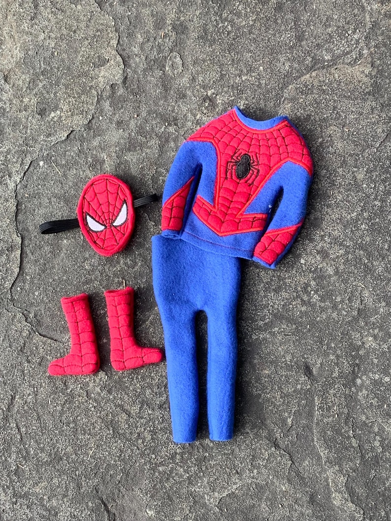 May include: A Spider-Man costume set, featuring a blue and red top with a spider emblem, matching blue pants, red boots, and a red mask with white eye details. The costume is made of soft fabric.
