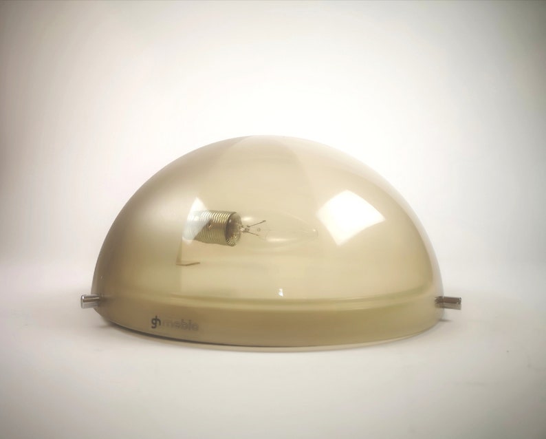 May include: A beige dome-shaped ceiling light fixture with a clear glass shade and a visible light bulb. The fixture has a metal base with the word "g-mobile" printed on it.