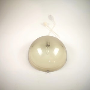 May include: A brown glass pendant light fixture with a white cord and a white ceiling mount.