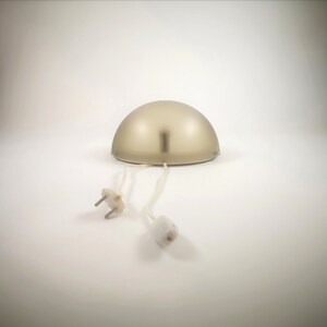 May include: A gold-colored dome-shaped lamp with a white cord and plug.