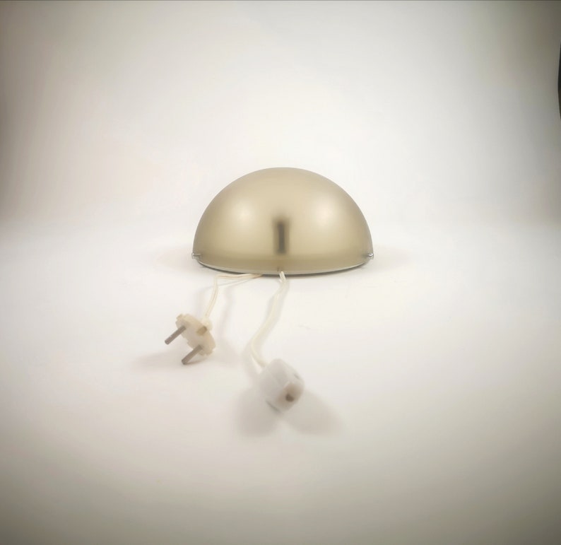 May include: A gold-colored dome-shaped lamp with a white cord and plug.
