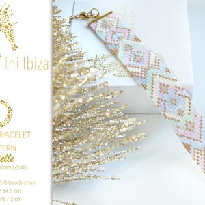 May include: A beaded loom bracelet with a geometric pattern in pastel colors of pink, blue, and gold. The bracelet is approximately 5.7 inches long and 0.8 inches wide. The image also includes text that reads "Ini Ibiza" and "Brielle".