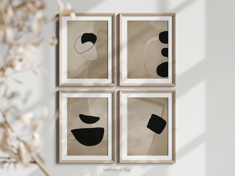 May include: Set of four abstract art prints in a minimalist style. Each print features a different combination of black and beige shapes on a beige background. The prints are framed in light wood frames.