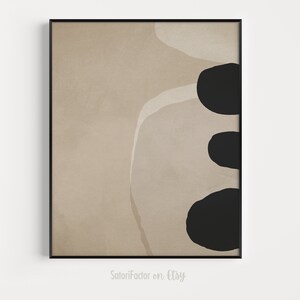 May include: Abstract art print with a beige background and three black shapes. The shapes are organic and resemble rocks or pebbles.