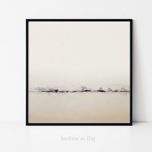 May include: A minimalist abstract landscape painting with a muted color palette. The painting features a thin line of trees and hills in shades of purple and brown against a white background. The painting is framed in a black frame.
