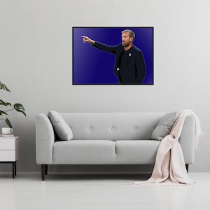 May include: A black and white photo of a man in a suit, pointing to the right. He is standing in front of a blue background.