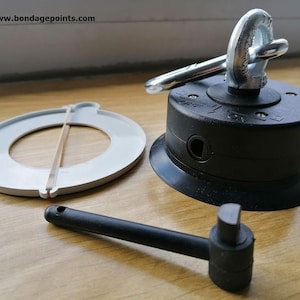 May include: A black suction cup with a silver swivel hook and a rubber ring. A white plastic ring with a rubber band and a black plastic handle are also included.