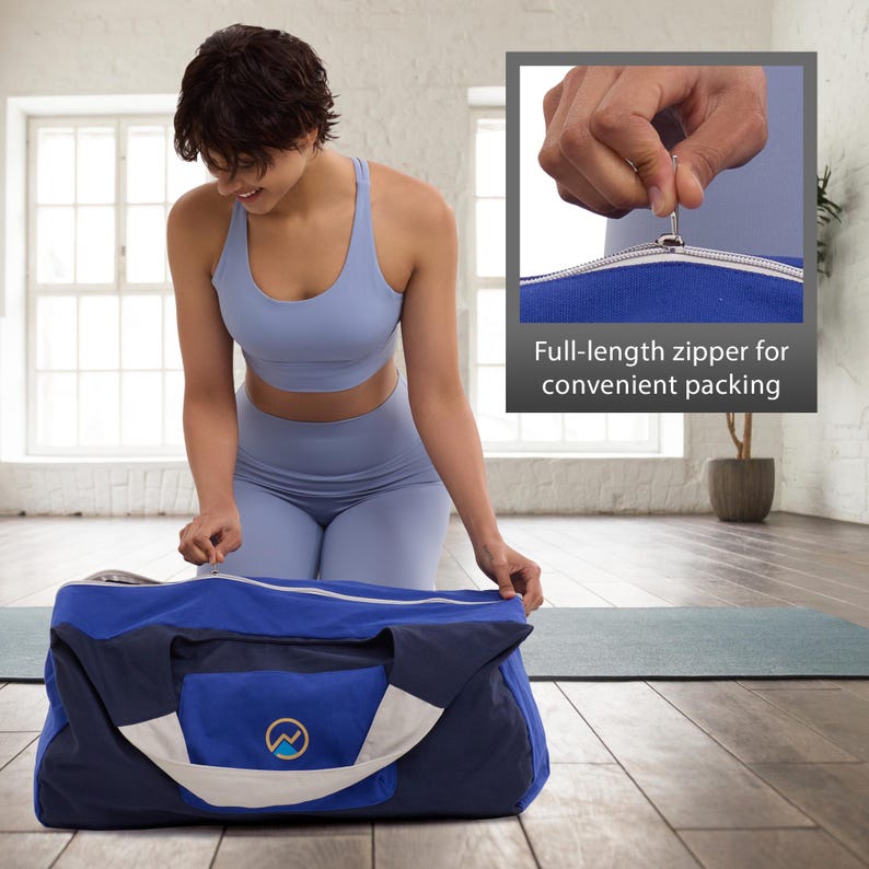 May include: A blue and navy duffel bag with a white accent and a mountain logo. The bag has a full-length zipper for convenient packing. The person in the image is wearing a light blue athletic outfit.