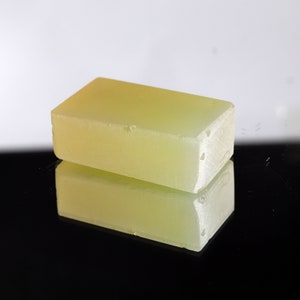 Puede incluir: Una barra rectangular de jab&oacute;n amarillo transl&uacute;cido. El jab&oacute;n es liso y tiene un ligero brillo.