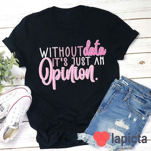 Peut inclure: T-shirt noir avec le texte "WITHOUT data IT'S JUST AN opinion." en lettres roses.