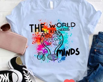 May include: Light blue t-shirt with a colorful graphic of a lightbulb with a brain inside. The text "The World Needs All Kinds of Minds" is printed on the shirt.