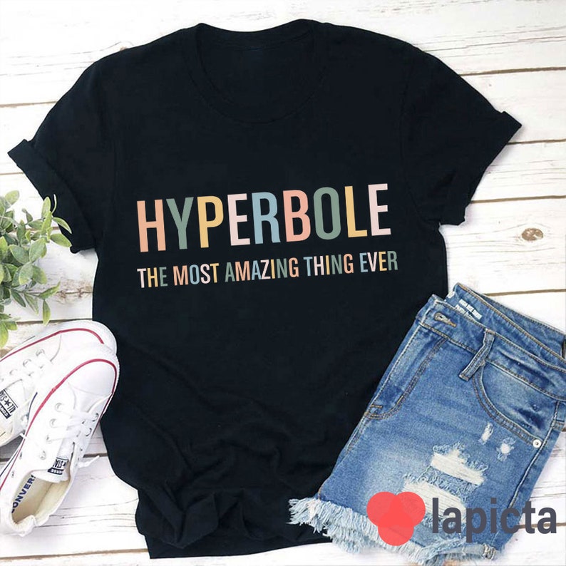 Pu&ograve; includere: Maglietta nera con il testo "HYPERBOLE THE MOST AMAZING THING EVER" in colori arcobaleno.