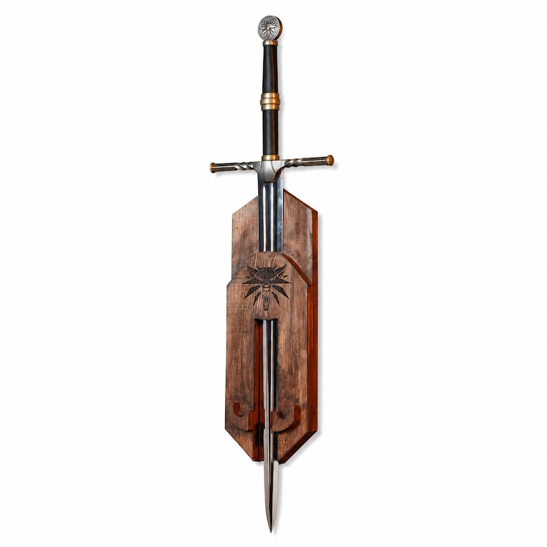 May include: A steel sword with a black grip, gold-colored accents, and a circular pommel, mounted on a vertical wooden plaque. The plaque features a dark wood finish and a carved wolf head emblem centered above the blade's resting position.