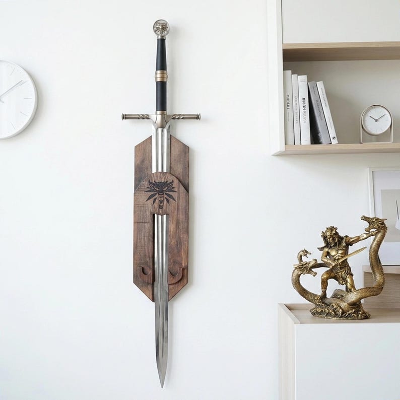 May include: A silver-toned metal sword with a black grip and a wolf-head pommel, mounted vertically on a dark brown wooden wall plaque. The plaque features a laser-engraved wolf head emblem centered above the blade, which tapers to a sharp point.