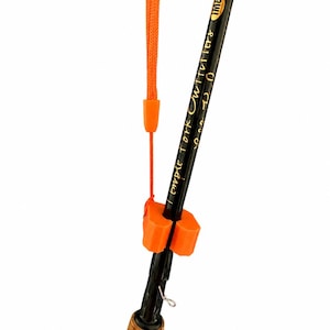 Pode incluir: Uma vara de pesca preta com texto dourado lendo Temple Fork Outfitters e IMG Graphite. Um flutuador de espuma laranja está preso à vara com um cordão laranja e um pequeno conector de plástico laranja, posicionado acima do cabo de cortiça.