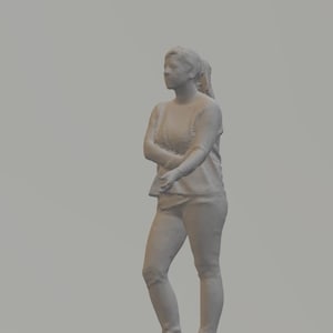 May include: A grey 3D model of a person wearing a long-sleeved shirt and jeans. The person is standing with their arms crossed and looking to the left.