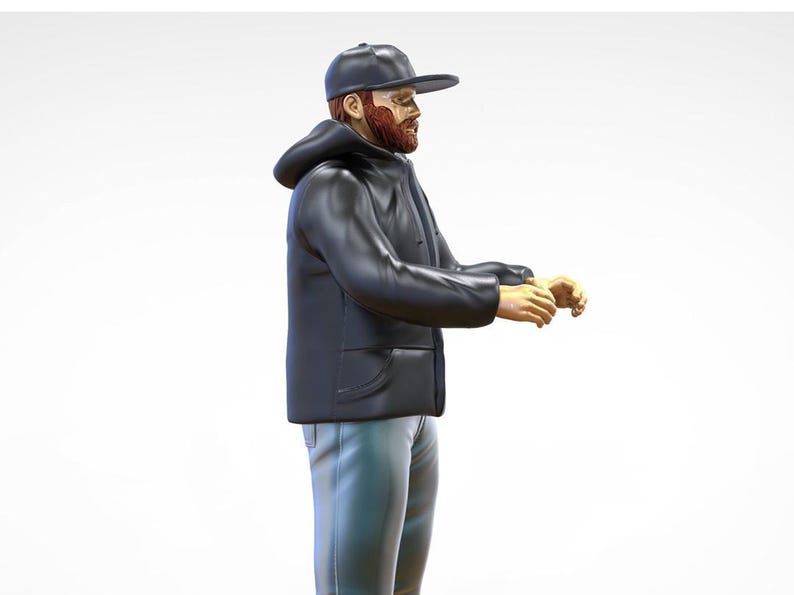 May include: A man wearing a black hooded jacket and a black baseball cap. He has a red beard and is standing with his arms outstretched.