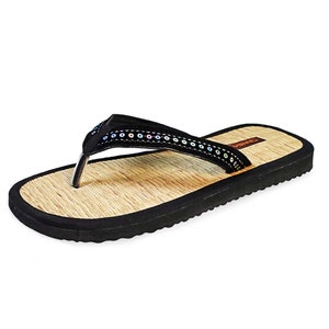 May include: Black flip-flop sandals with a brown woven footbed and a black strap with iridescent sequins.