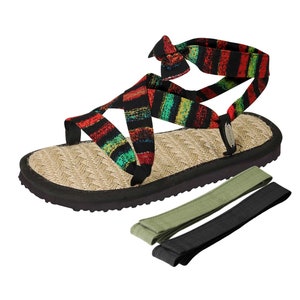 May include: A pair of black, red, green, and yellow striped sandals with a jute sole and a black rubber outsole. The sandals have a criss-cross strap design and come with two extra straps in black and green.