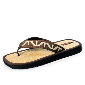 May include: Brown leather thong sandals with a woven straw footbed and a brown and beige patterned strap.
