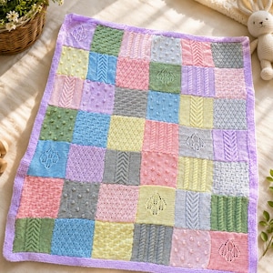 May include: A rectangular knitted baby blanket featuring a patchwork design of multicoloured squares in pastel shades of pink, blue, yellow, green, and grey. Each square displays a unique textured pattern, including cables, bobbles, and lace.