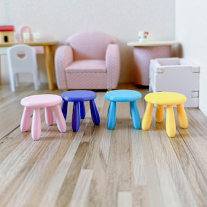 May include: Four small, colourful stools with rounded tops and four legs. The stools are pink, blue, light blue, and yellow.