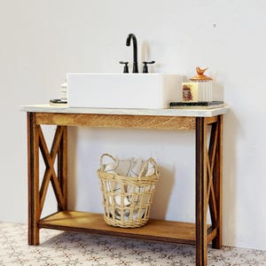 May include: A white porcelain sink with a black faucet sits on a wooden vanity with a woven basket on the lower shelf. The vanity has a rustic, farmhouse style with a distressed wood finish.