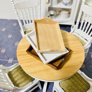 May include: Three wooden trays stacked on top of each other. The top tray is light brown, the middle tray is white, and the bottom tray is dark brown.