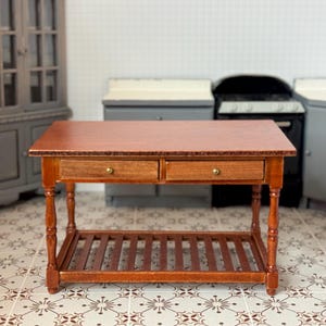 Puede incluir: Una isla de cocina de madera con dos cajones y un estante inferior. La isla está hecha de madera marrón oscura y tiene un acabado de madera natural.