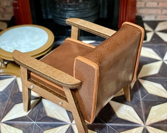 May include: A brown leather armchair with wooden legs and arms. The chair is sitting on a patterned floor.