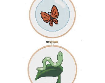 May include: Two cross-stitch embroidery hoops. The top hoop features an orange butterfly inside a blue bubble. The bottom hoop shows a green caterpillar on a green leaf. The brand name "BlancheStitches" is above the hoops.