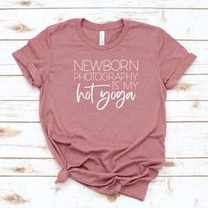 Peut inclure: Un t-shirt mauve avec le texte "NEWBORN PHOTOGRAPHY IS MY HOT YOGA" en blanc.