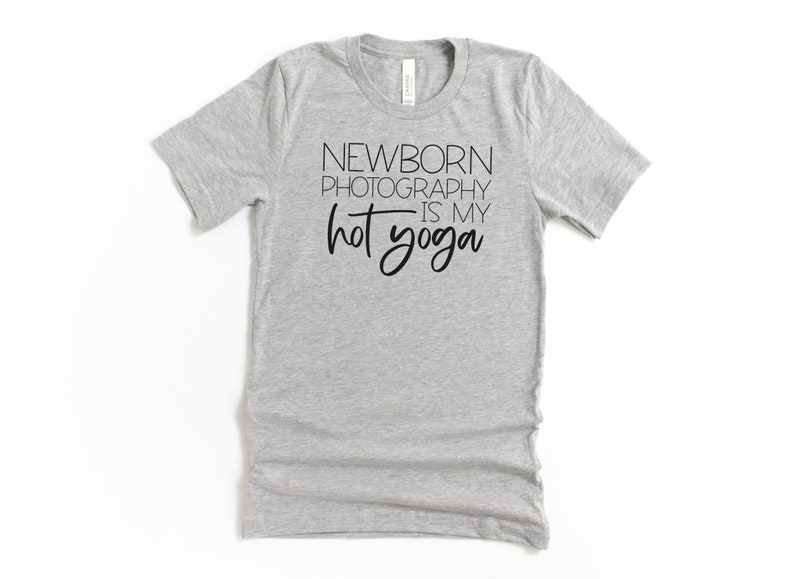 Peut inclure: T-shirt gris avec un texte noir qui dit "Newborn Photography is my hot yoga".