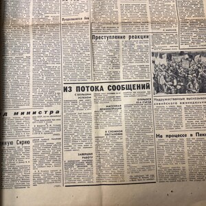 May include: A black and white newspaper page with the headline "Из потока сообщений" (From the flow of messages) and a photo of a crowd of people. The text on the page is in Russian.