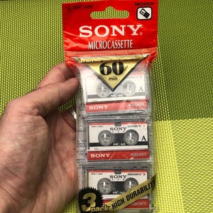 May include: A pack of three Sony microcassette tapes, each with a red label and the text "60 min" and "MC-60". The pack is labelled "3 pack High Durability".