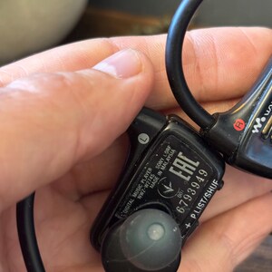 May include: A black Sony Walkman digital music player, model NWZ-W274S, featuring an in-ear design with a wrap-around band. The device displays the text 'DIGITAL MUSIC PLAYER', 'NWZ-W274S', 'SONY', 'MADE IN MALAYSIA', 'EAC', '6793949', and 'P.LIST/SHUF'.