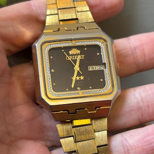 May include: A white ceramic mug with a black handle and the text "But First, Coffee" in a bold, black font. The mug is set against a neutral background, highlighting its simple design.