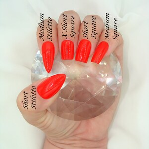May include: A hand model shows different nail shapes and lengths, including short stiletto, X-short square, short square, medium square, and medium stiletto. All nails are painted a bright red.