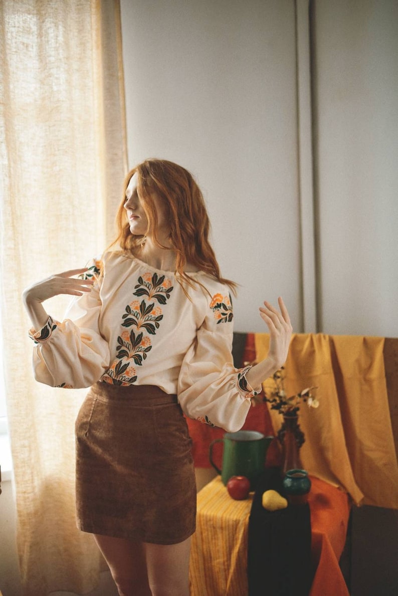 Creamy peach cotton vyshyvanka blouse made in Ukraine. The cut is puffy sleeves embroidered with birds, and also the blouse has floral motifd on the chest. Made in Ukraine in stock. Also linen option is available.