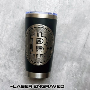 May include: Black stainless steel tumbler with a laser engraved design of a Bitcoin logo. The logo features the Bitcoin symbol and the words "Bitcoin Digital Decentralized Peer to Peer".